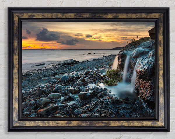 Water flows down the rocks into the sea Framed Print