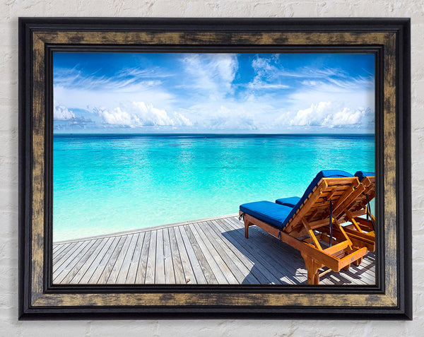 sunchairs on decking on the beach Framed Print