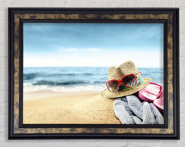 Sun hat and sunglasses on the beach Framed Print