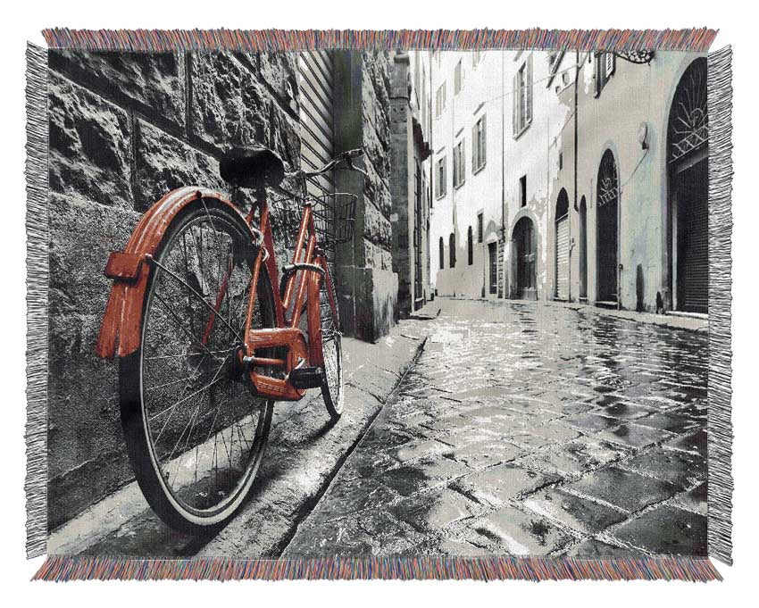 Red Bicycle In The Cobbled Streets Woven Blanket