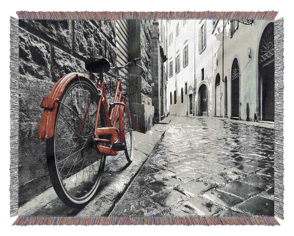 Red Bicycle In The Cobbled Streets Woven Blanket